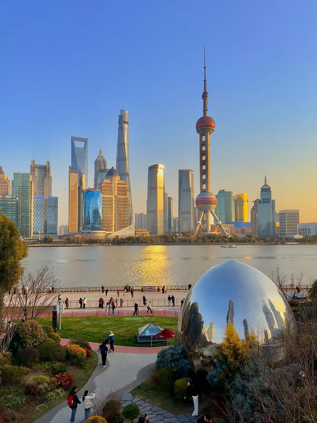 Sunrise over Shanghai North Beach showing calm water and few visitors