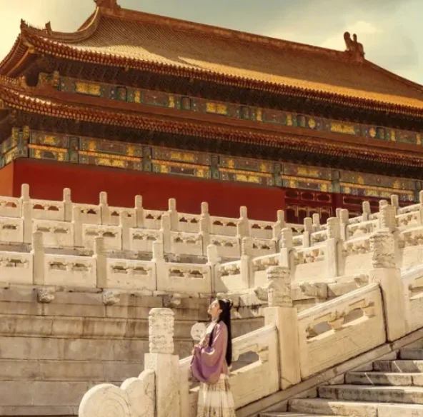 Sunset view of the Forbidden City rooftops with glowing orange sky