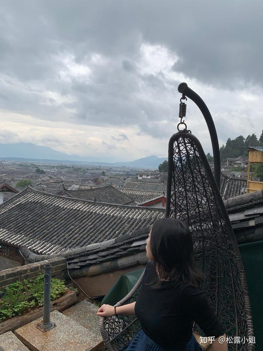 Lijiang old town rooftops seen from a terrace under cloudy mountain light