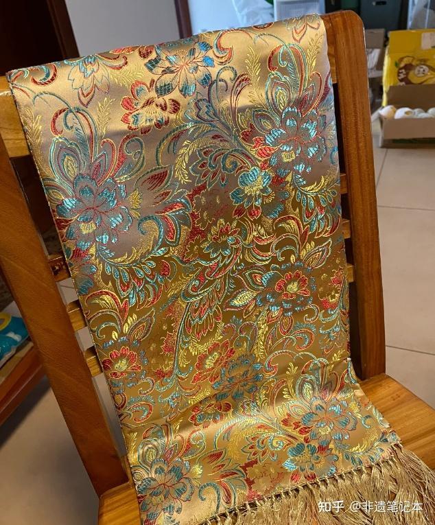 Gold-toned Nanjing Yunjin brocade textile draped over a chair