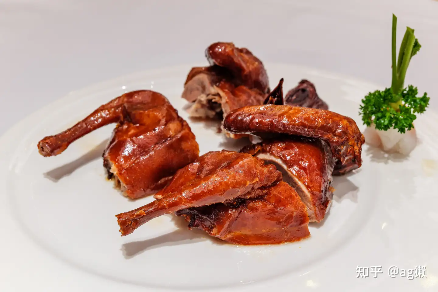 Slices of Beijing roast duck arranged on a white plate