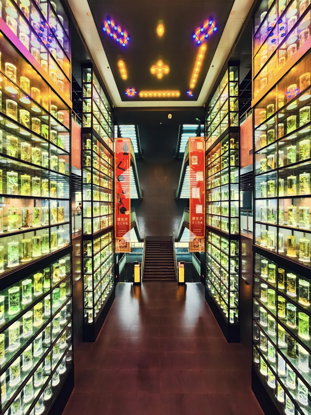 A narrow Guangzhou interior corridor filled with bright neon-like display panels