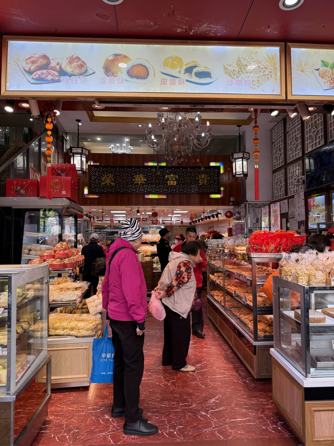 A busy Guangzhou pastry and teahouse counter with traditional signage and local customers