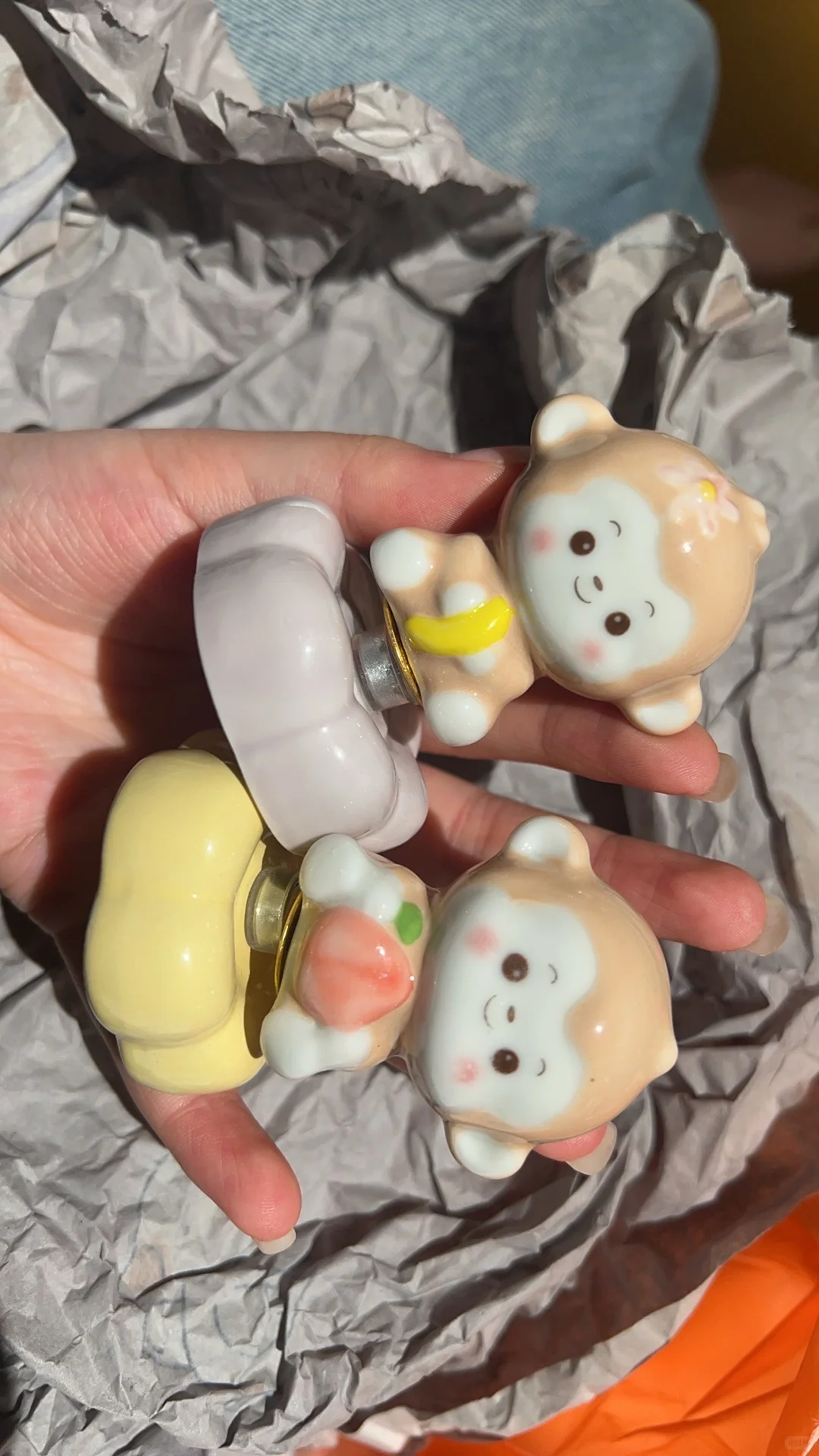 Small colorful ceramic figures held in a hand after visual review for a craft article