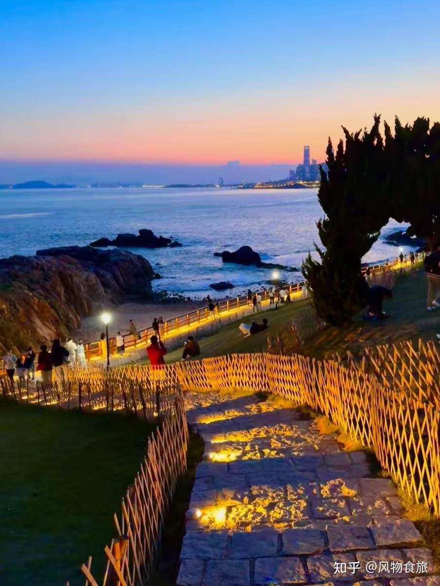 A sunset coastal path view in Qingdao with warm lights and the sea in the background